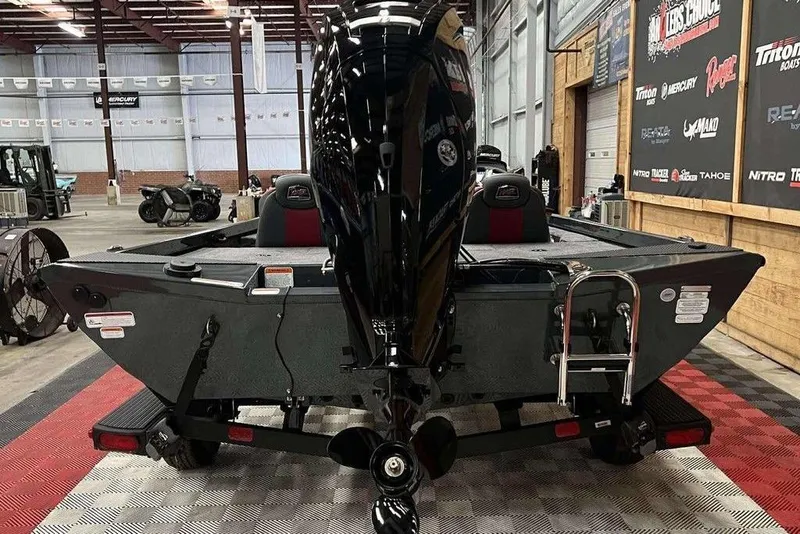 Slide: The Image of 2026 Ranger RT178 boat in showroom, rear view with motor and ladder. - 2