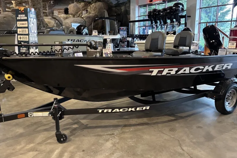 The Image of 2026 Tracker Super Guide V-16 T fishing boat displayed indoors on a trailer. - 0