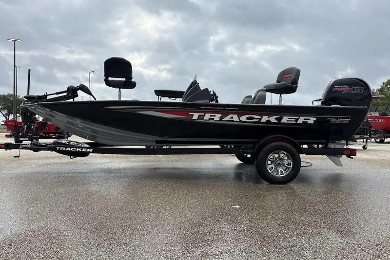 The Image of 2026 Tracker Pro Team 195 boat on trailer, parked outdoors on wet pavement. - 0