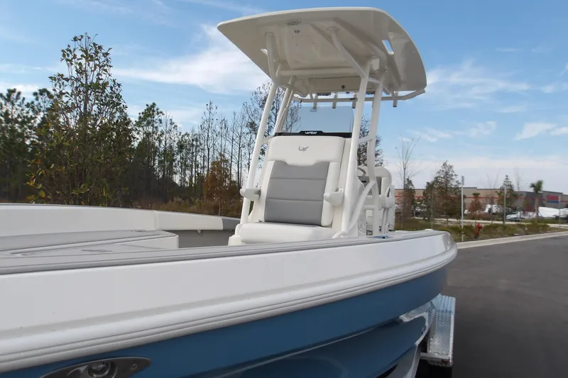 Slide: The Image of 2026 Mako 24 APEX boat with T-top, parked outdoors on a trailer. - 14