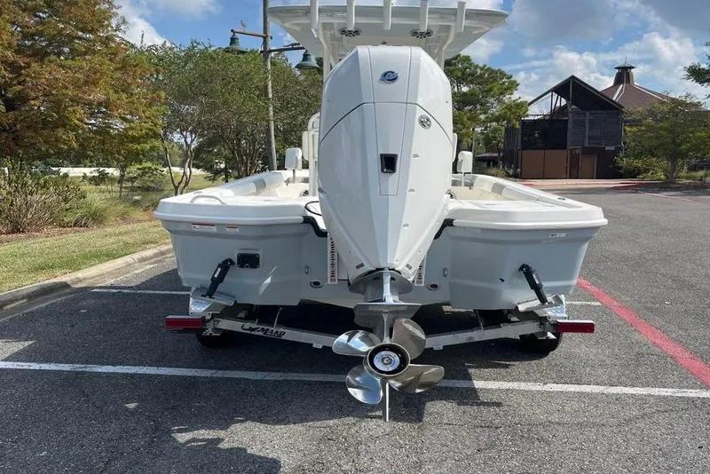 Slide: The Image of 2026 Mako 24 APEX boat on trailer in parking lot, sunny day. - 3