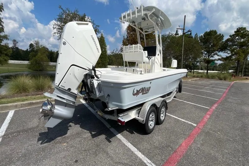 Slide: The Image of 2026 Mako 24 APEX boat on trailer, parked outdoors under a blue sky. - 4