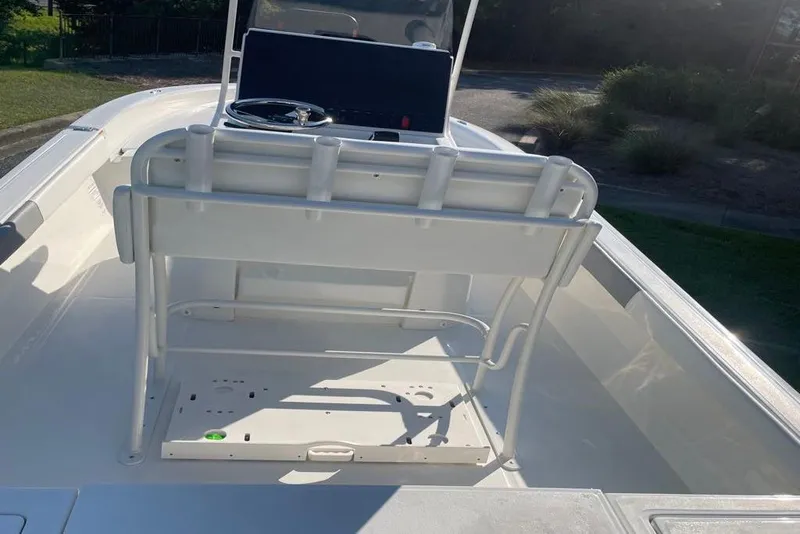 Slide: The Image of 2026 Mako 24 APEX boat on trailer outside Outdoor World store. - 2