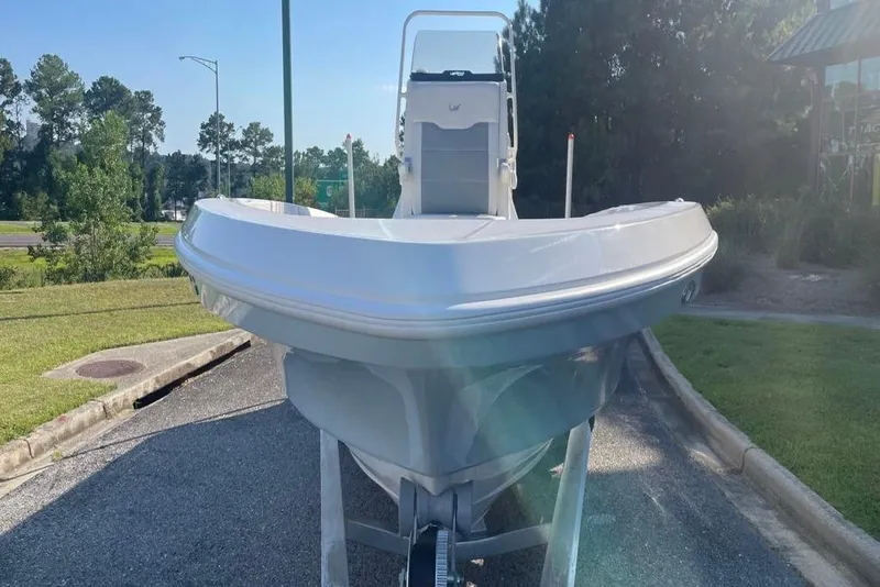 Slide: The Image of 2026 Mako 24 APEX boat on trailer, parked outdoors in sunny setting. - 88