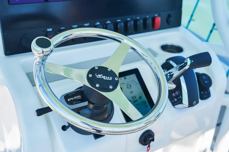 Slide: The Image of Steering console of 2026 Mako 24 APEX boat with chrome wheel and controls. - 63