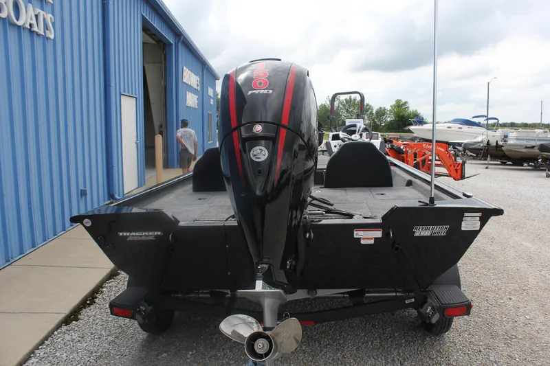 Slide: The Image of 2026 Tracker Pro Team 195 boat with powerful outboard motor, parked near blue building. - 11