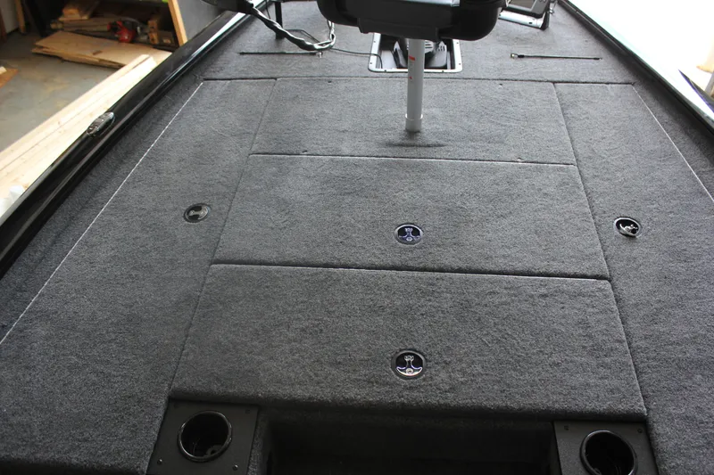Slide: The Image of 2026 Tracker Pro Team 195 boat deck with carpeted surface and storage compartments. - 8
