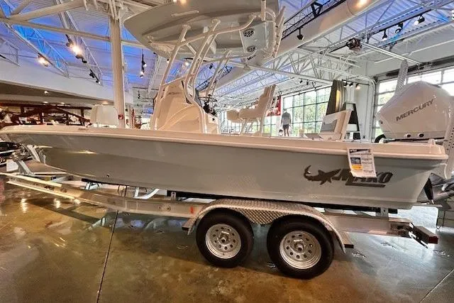 Slide: The Image of 2026 Mako 24 APEX boat on display in a showroom with trailer. - 1