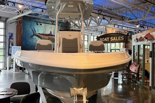 Slide: The Image of 2026 Mako 24 APEX boat displayed in a showroom with marine-themed decor. - 3