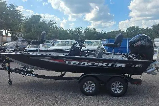 Slide: The Image of 2026 Tracker Pro Team 195 boat on trailer, parked outdoors under a cloudy sky. - 2