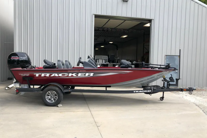 Slide: The Image of 2026 Tracker Pro Team 195 boat in red, parked outside a metal building. - 16