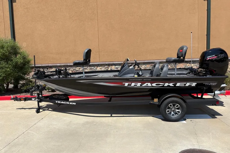 The Image of 2026 Tracker Pro Team 195 boat on trailer, black with red accents, parked outdoors. - 0