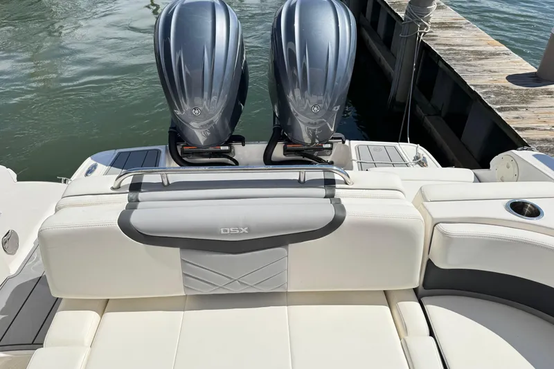 Slide: The Image of 2022 Chaparral 280 OSX boat with dual outboard engines docked by the water. - 11