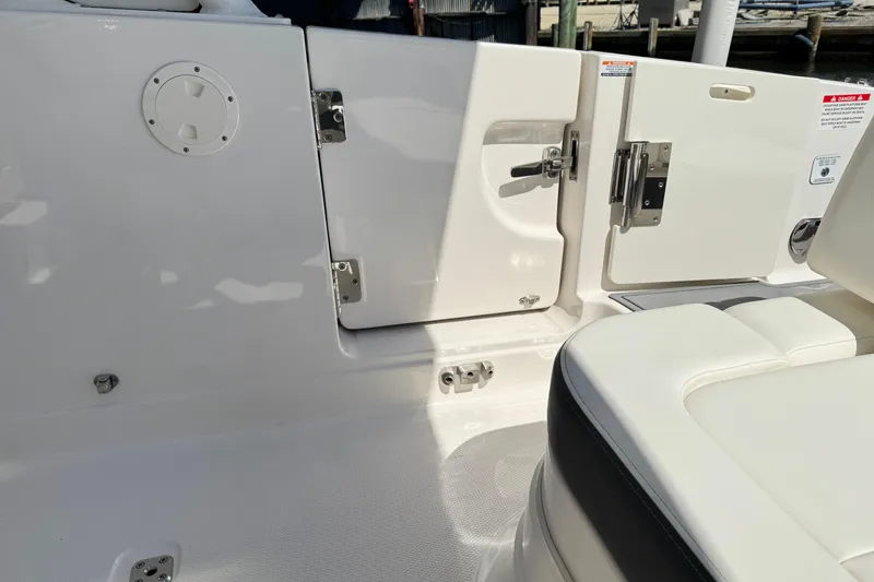 Slide: The Image of 2022 Chaparral 280 OSX boat interior with white seating and storage compartments. - 13