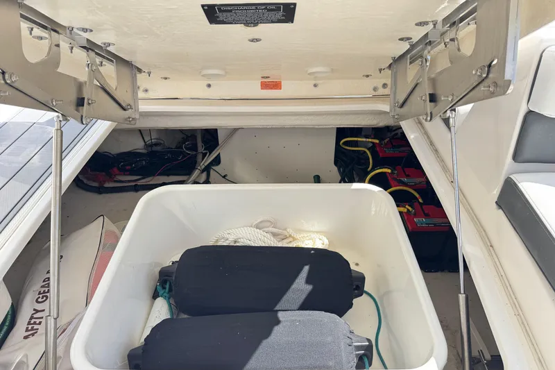Slide: The Image of Storage compartment of 2022 Chaparral 280 OSX boat with safety gear and batteries. - 16