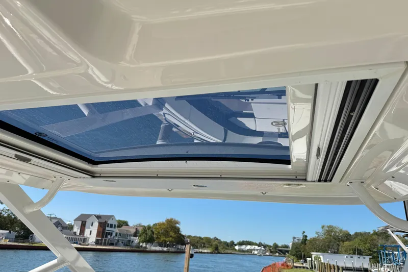 Slide: The Image of 2022 Chaparral 280 OSX boat with sunroof, overlooking a scenic waterfront view. - 28
