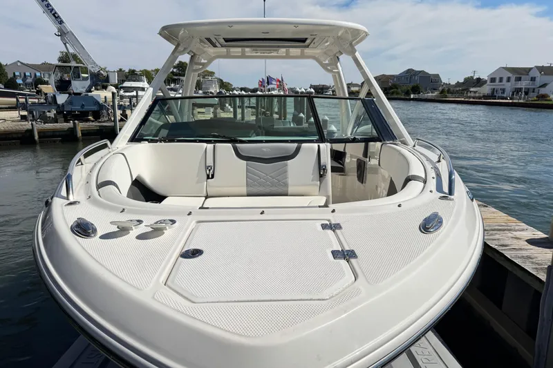 Slide: The Image of 2022 Chaparral 280 OSX boat docked by waterfront homes under a clear sky. - 35