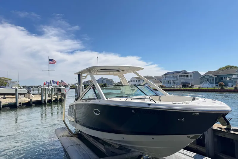 Slide: The Image of 2022 Chaparral 280 OSX boat docked at a marina under a clear blue sky. - 36