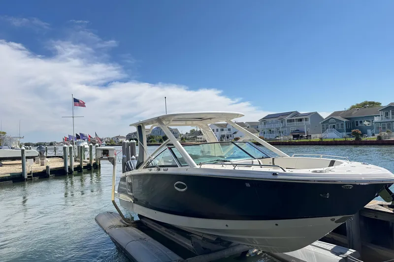 Slide: The Image of 2022 Chaparral 280 OSX boat docked at a marina under a clear blue sky. - 37