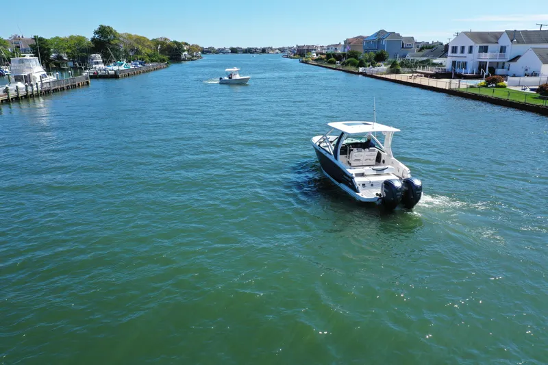 Slide: The Image of 2022 Chaparral 280 OSX boat cruising on a scenic waterway with waterfront homes. - 40