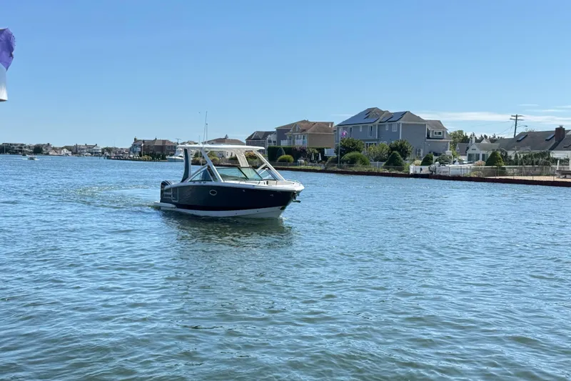 Slide: The Image of 2022 Chaparral 280 OSX boat cruising on a sunny day near waterfront homes. - 41