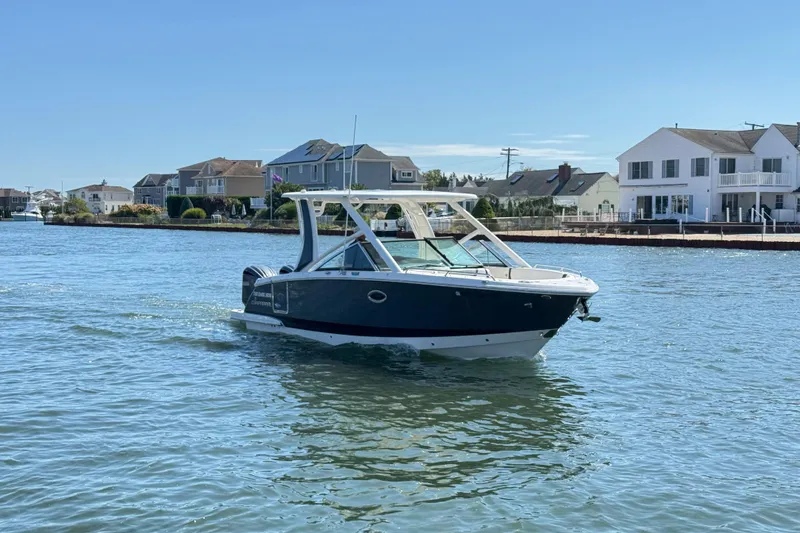 Slide: The Image of 2022 Chaparral 280 OSX boat cruising on a sunny day near waterfront homes. - 42