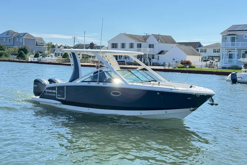 Slide: The Image of 2022 Chaparral 280 OSX boat cruising on a sunny day near waterfront homes. - 43