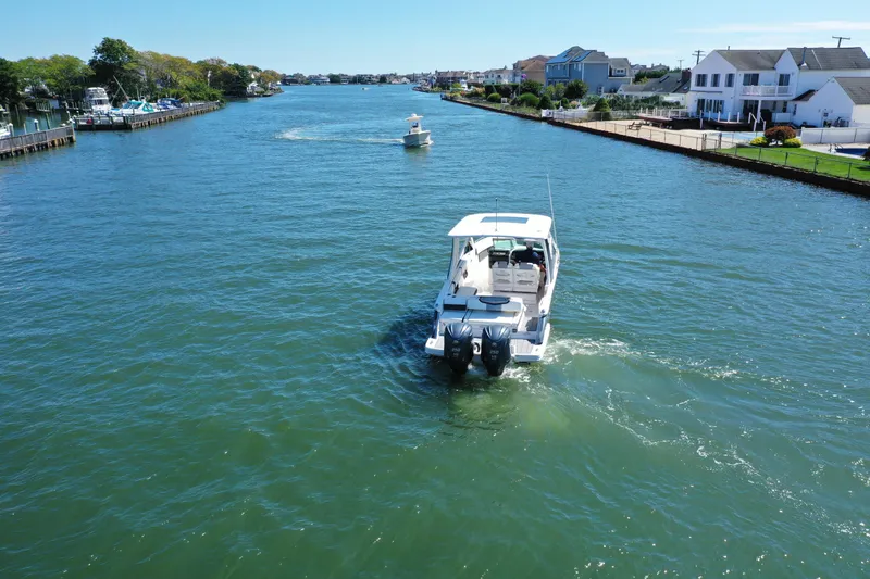 Slide: The Image of 2022 Chaparral 280 OSX boat cruising on a scenic waterway with waterfront homes. - 5