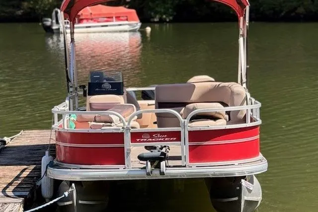 Slide: The Image of 2017 Sun Tracker Bass Buggy 18 DLX pontoon boat docked on a calm lake. - 14