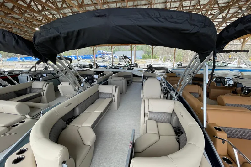 Slide: The Image of 2026 Harris Cruiser 230 pontoon boat with spacious seating under a covered dock. - 17