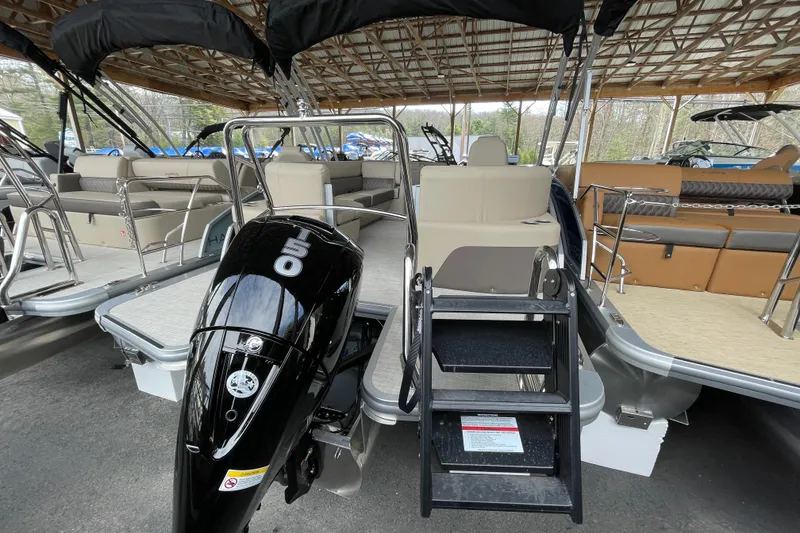 Slide: The Image of 2026 Harris Cruiser 230 pontoon boat with outboard motor and seating under a canopy. - 19