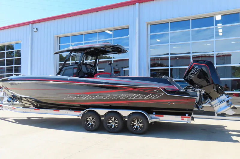 Slide: The Image of 2026 Sunsation 32CCX boat on trailer, sleek black design with red accents, parked outdoors. - 3