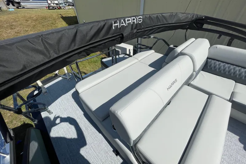 Slide: The Image of 2026 Harris Cruiser 210 SL boat interior with sleek seating and branded cover. - 6
