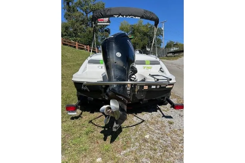 Slide: The Image of 2021 Tahoe T16 boat with outboard motor on trailer, parked on grass. - 5