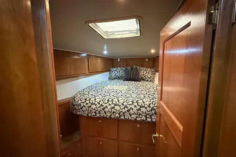 Slide: The Image of Cozy bedroom in 2003 Navigator 53 yacht with floral bedding and wooden cabinetry. - 8