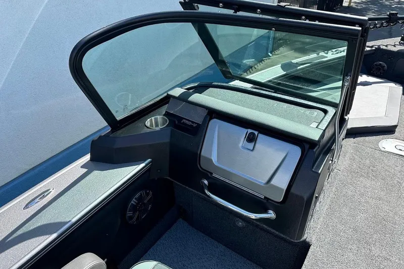 Slide: The Image of 2025 Lund 1875 Pro-V boat interior with windshield and storage compartment. - 17