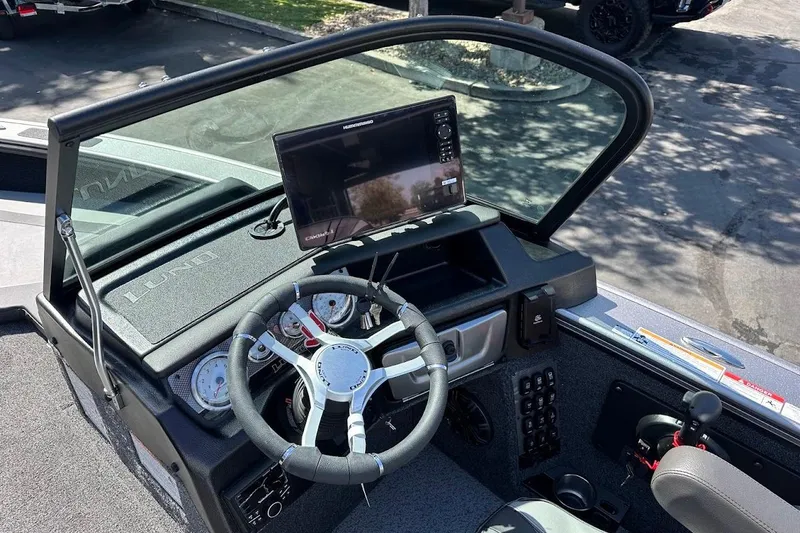 Slide: The Image of 2025 Lund 1875 Pro-V boat dashboard with steering wheel and electronic display. - 23