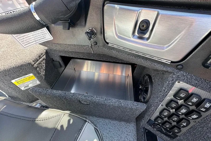 Slide: The Image of 2025 Lund 1875 Pro-V boat interior with open storage compartment and control panel. - 29