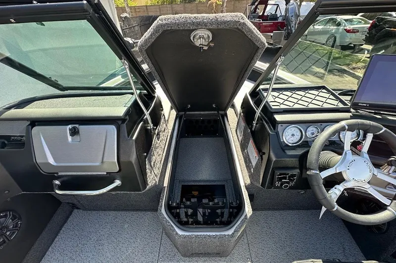 Slide: The Image of 2025 Lund 1875 Pro-V boat interior with steering wheel, dashboard, and storage compartment. - 32