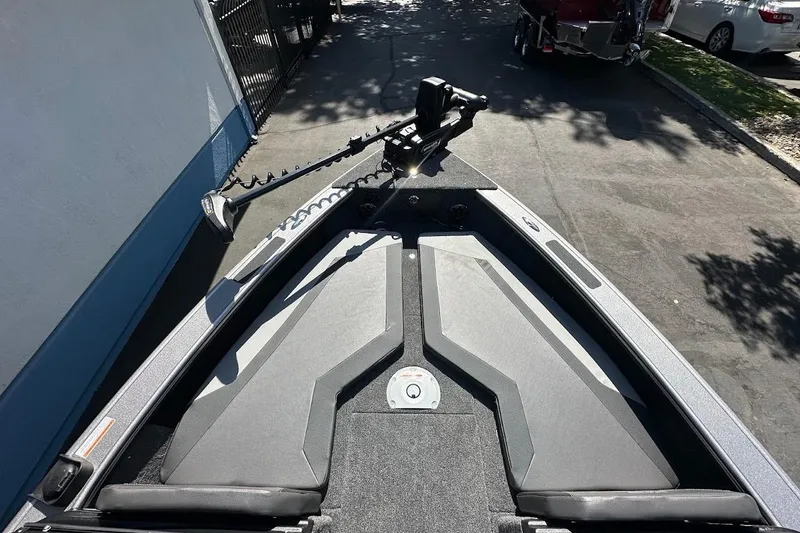 Slide: The Image of 2025 Lund 1875 Pro-V boat deck with trolling motor, parked on a sunny driveway. - 36