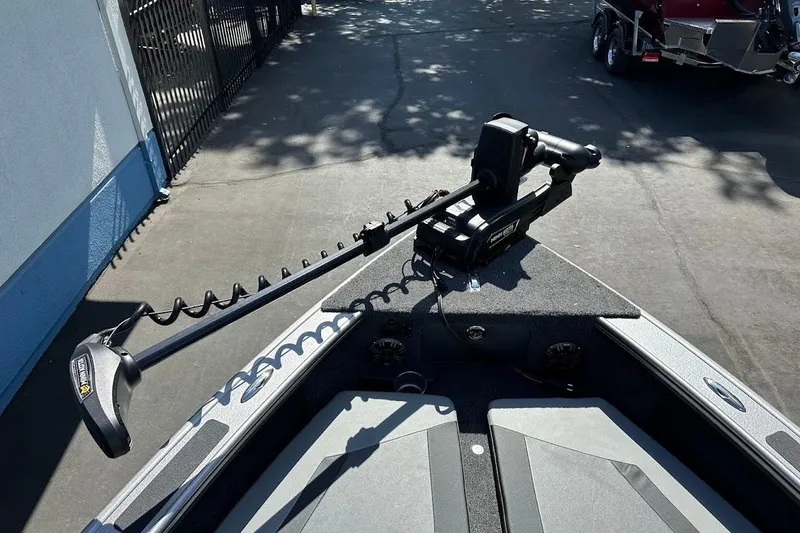 Slide: The Image of 2025 Lund 1875 Pro-V boat with trolling motor on deck, parked outdoors. - 37