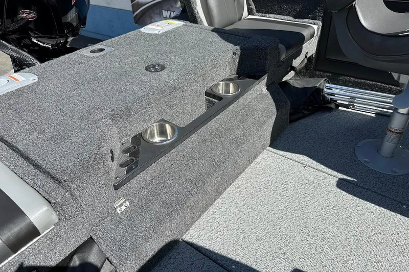 Slide: The Image of 2025 Lund 1875 Pro-V boat interior with carpeted seating and built-in cup holders. - 42