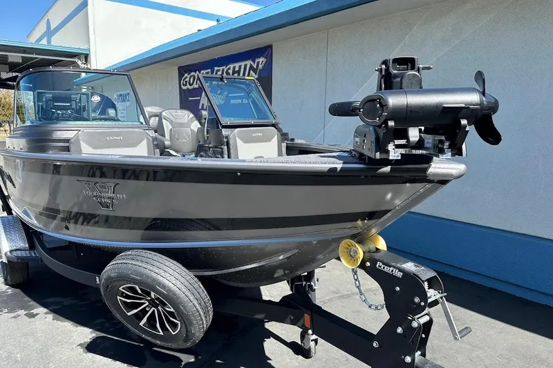 Slide: The Image of 2025 Lund 1875 Pro-V boat on trailer, parked outdoors, showcasing sleek design and modern features. - 5