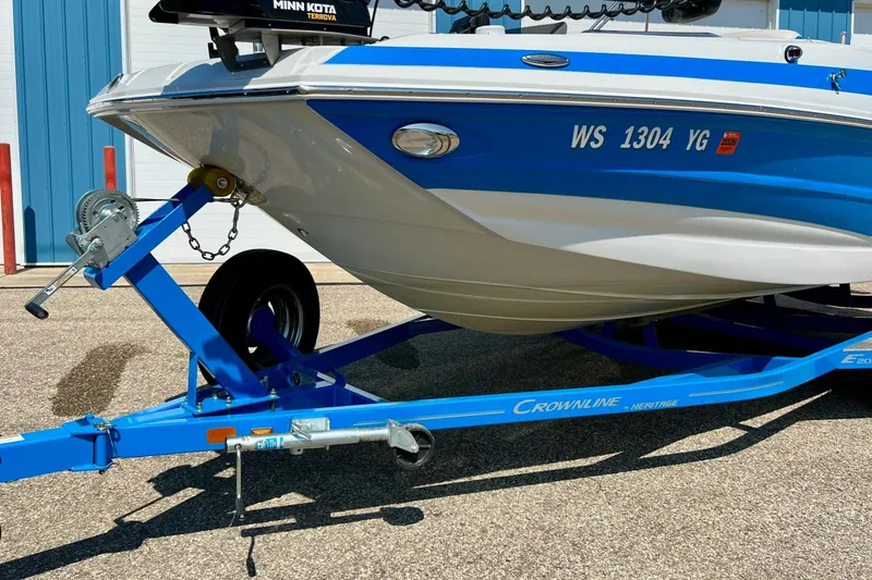 Slide: The Image of 2020 Crownline Eclipse E205 XS Fish boat on blue trailer, parked outdoors. - 13
