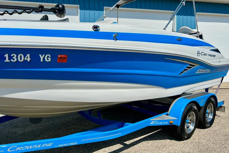 Slide: The Image of 2020 Crownline Eclipse E205 XS Fish boat on trailer, blue and white design. - 14