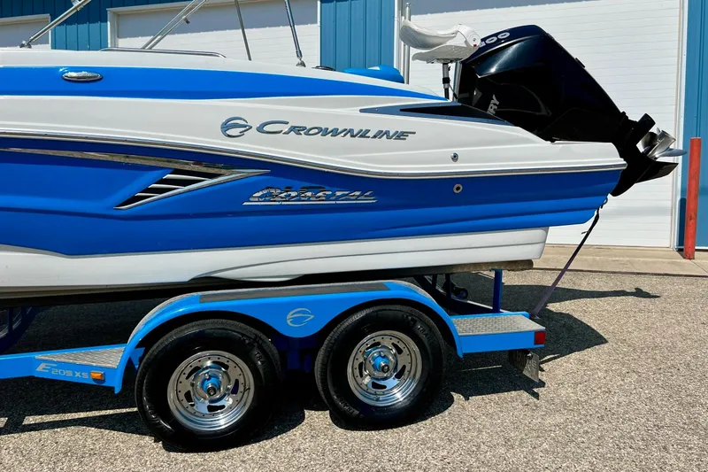 Slide: The Image of 2020 Crownline Eclipse E205 XS Fish boat on trailer, blue and white design. - 15