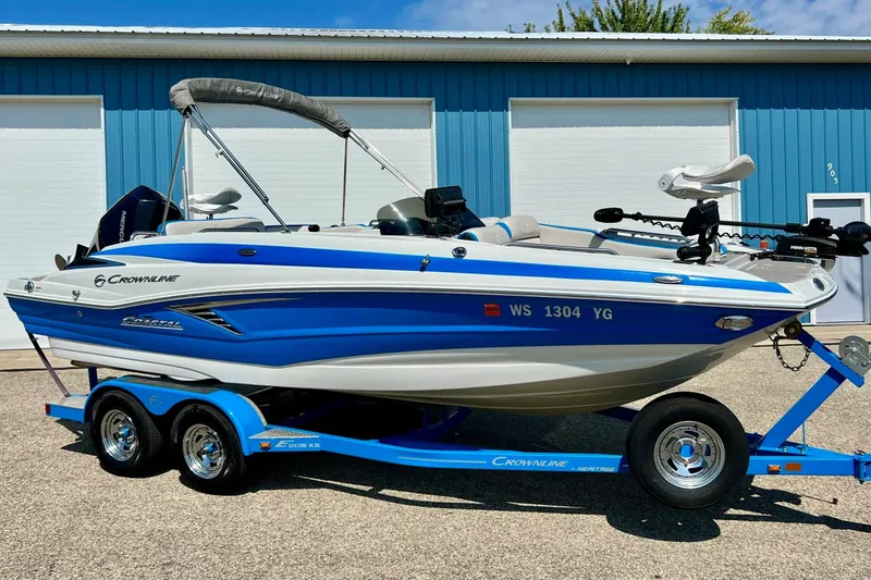 Slide: The Image of 2020 Crownline Eclipse E205 XS Fish boat on trailer, blue and white design. - 2
