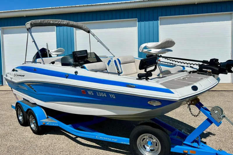 Slide: The Image of 2020 Crownline Eclipse E205 XS Fish boat on trailer, blue and white design. - 4