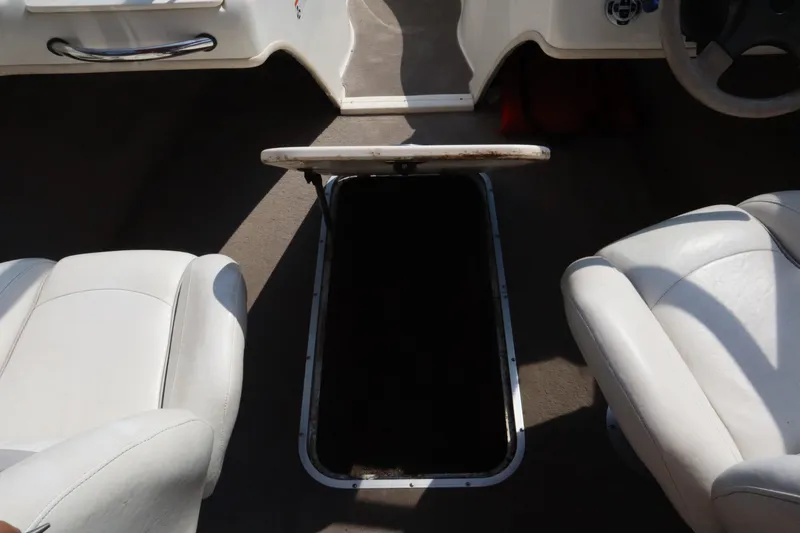 Slide: The Image of 2008 Stingray 195 LS/LX/LR boat interior with open storage compartment between seats. - 17