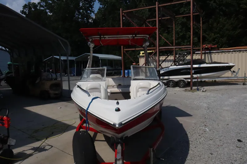 Slide: The Image of 2008 Stingray 195 LS/LX/LR boat with red accents, parked outdoors. - 3
